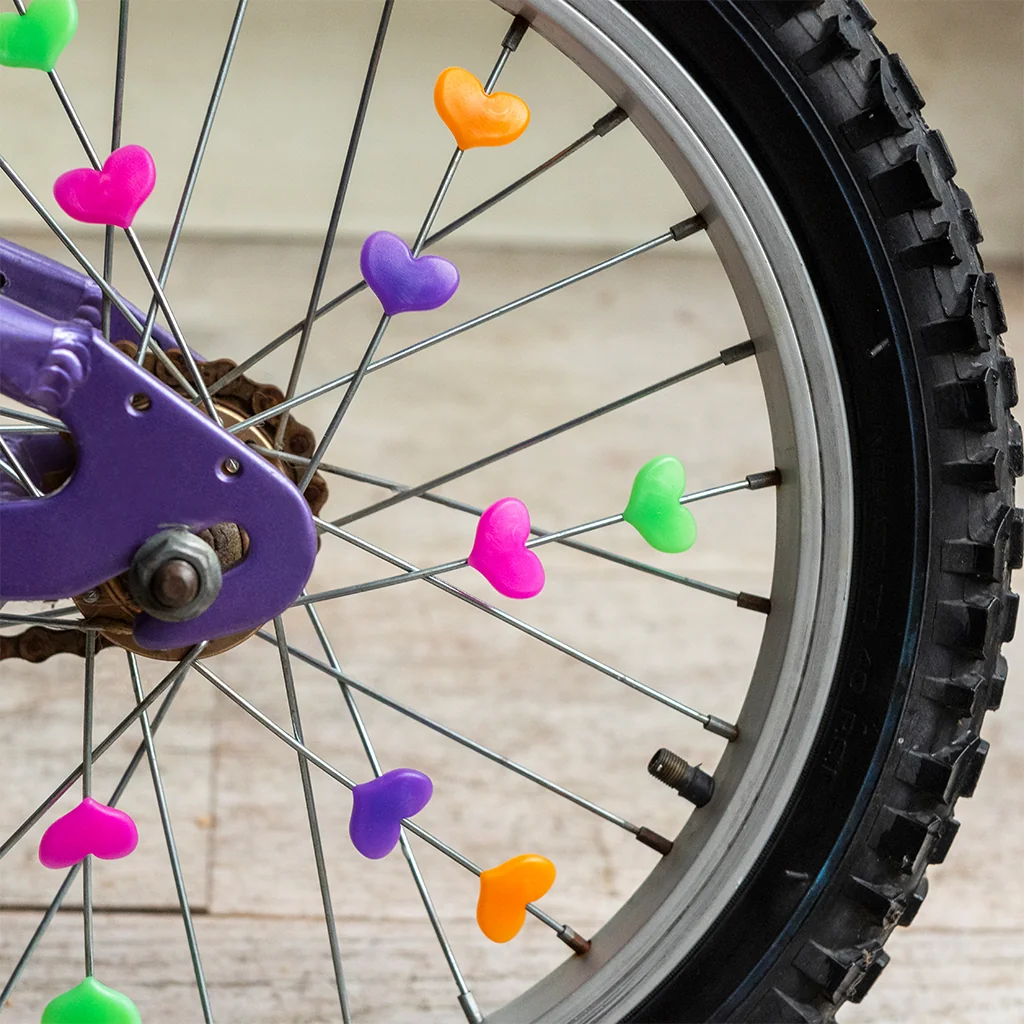Cœurs colorés clipsés sur les rayons d’une roue de vélo