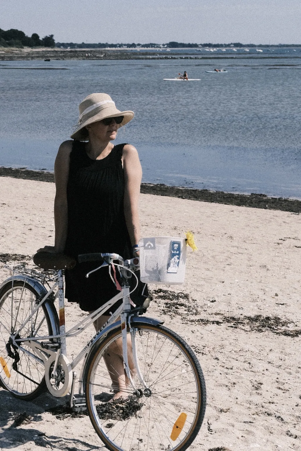 Cycliste en robe avec son vélo au bord de l’eau
