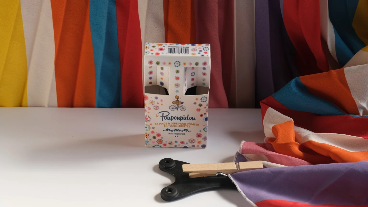 Le Poupoupidou, pince à jupe magnétique, présenté avec des tissus colorés